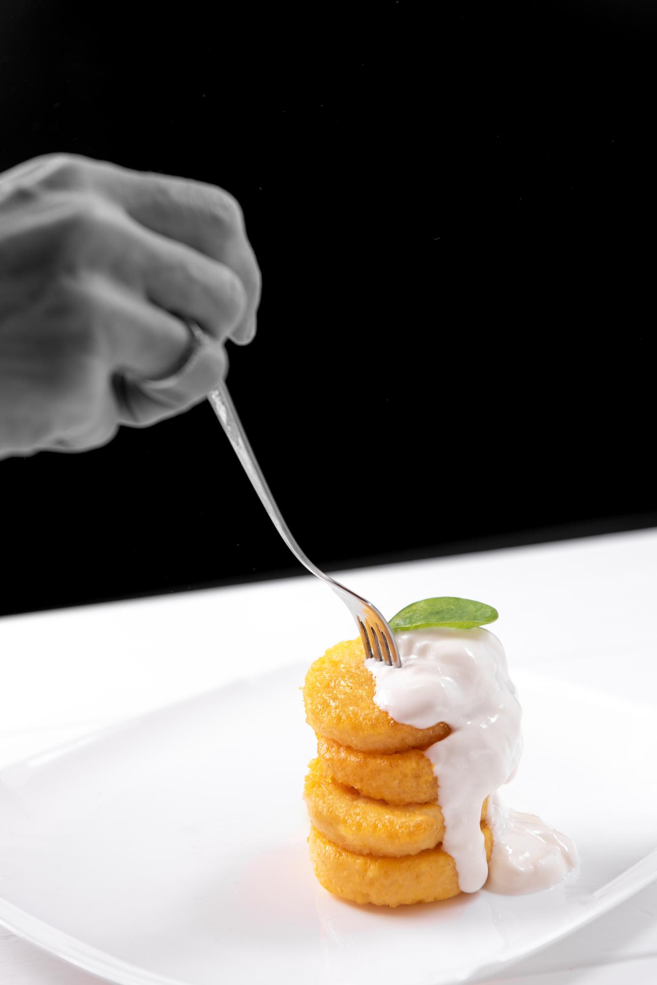 hands plating a modern appetizer with tweezers